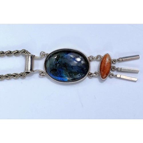 725C - A white metal pendant, stamped 1925, set with oval labradorite cabochon stone and lower brown agate ... 