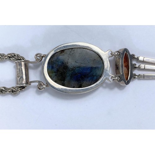 725C - A white metal pendant, stamped 1925, set with oval labradorite cabochon stone and lower brown agate ... 