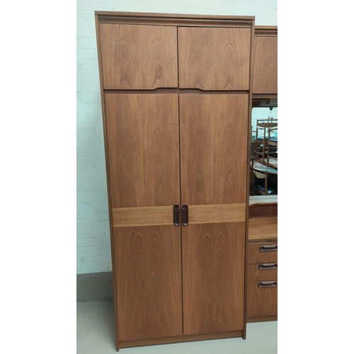 832 - A large 1960's sectional teak bedroom wall unit with wardrobes to each end and a central fitted sect... 