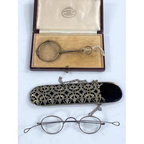 651 - A cased pair of lorgnette; a pair of 19th century steel rimmed spectacles in ornate pierced metal ca... 