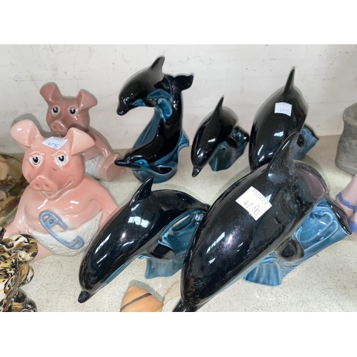 471B - Five POOLE Dolphins; two WADE Piggy Bank figures and other resin Pig.