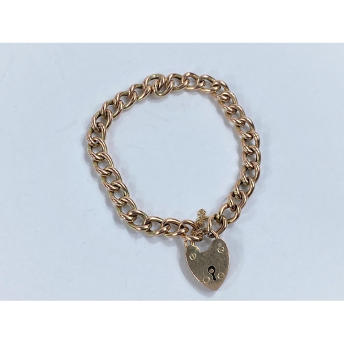 758 - A yellow metal curb link bracelet with 9 carat hallmarked gold heart lock, 10gm tests as 9ct