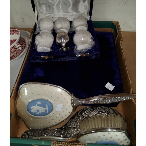 62 - A white metal cased hand mirror with relief decoration of cherubs; a Wedgwood mirror and hairbrush; ... 