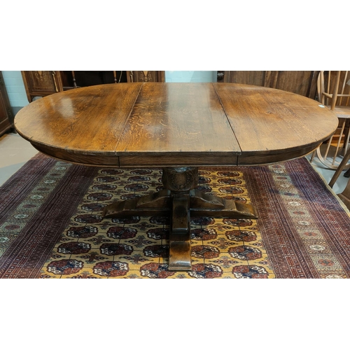 784 - An oak circular, pedestal extending dining table with on spare leaf, in the Titchmarsh & Goodwin... 