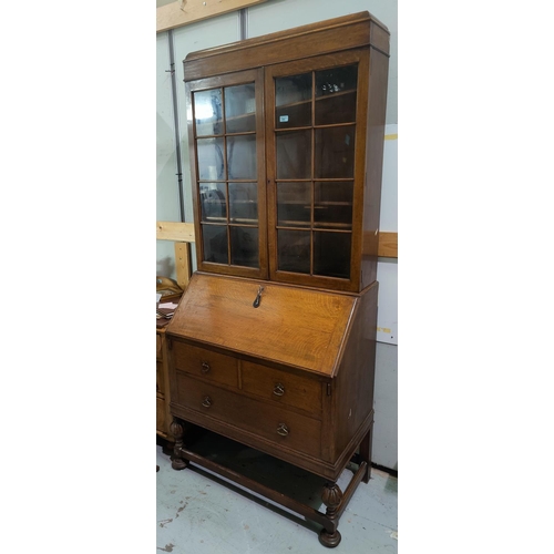 791 - A 1930's oak bureau bookcase with double glazed doors above, one long and two short drawers with car... 