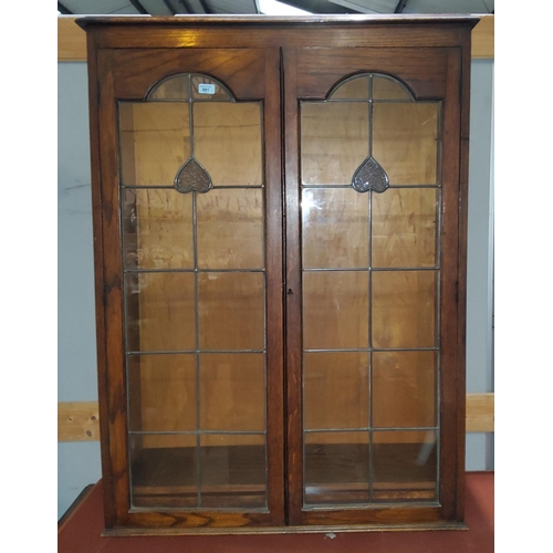 881 - A 1930's oak bookcase enclosed by coloured and leaded glass doors