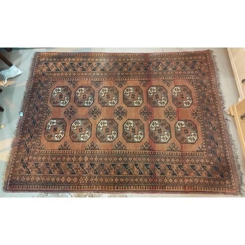 894 - A 20th century hand knotted Persian rug, rust ground with 12 elephant foot motifs to the field, 95 x... 