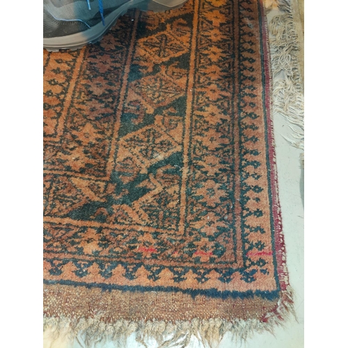 894 - A 20th century hand knotted Persian rug, rust ground with 12 elephant foot motifs to the field, 95 x... 