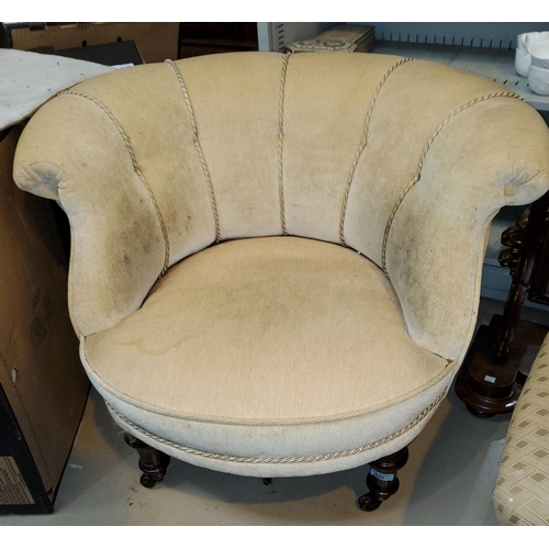 820 - A Victorian low tub armchair on turned supports and castors, upholstered in cream fabric