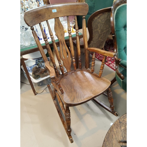 874 - A Victorian elm rocking armchair with fiddle back