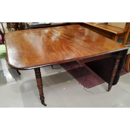 943A - A Georgian mahogany large drop leaf dining table with turned legs