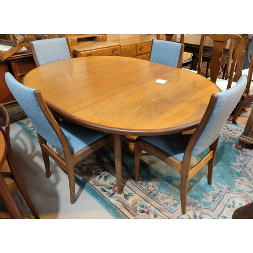947 - A mid 20th century G-plan teak circular extending dining table and four matching chairs reupholstere... 