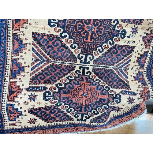 896 - A small 20th century hand knotted carpet with rust ground, signed and dated