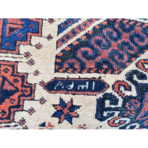 896 - A small 20th century hand knotted carpet with rust ground, signed and dated