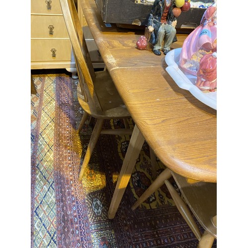 912 - A 1960's Ercol elm and beech dining suite comprising 6 hoop and stick back chairs and table with dro... 