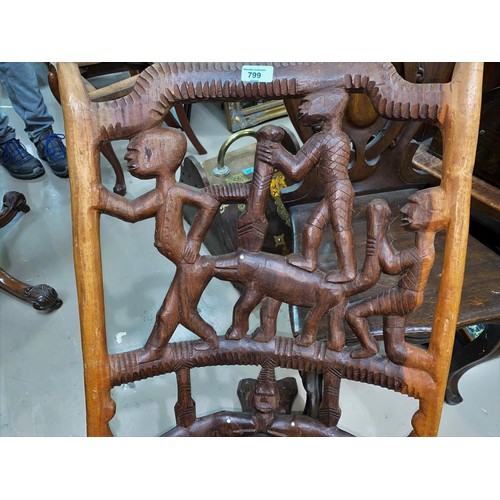 799 - A carved and pierced African tribal folding chair, figures and hippopotami to the back