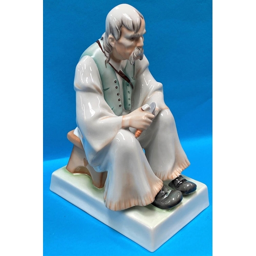 481 - A Hungarian Zsolnay Pecs porcelain figurine of a seated old man carving wood