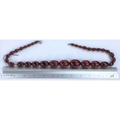 626 - A string of 32 cherry amber bakelite graduating beads, from 1cm to 3cm, with internal streaking, 85.... 