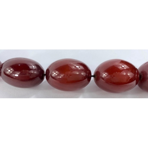 626 - A string of 32 cherry amber bakelite graduating beads, from 1cm to 3cm, with internal streaking, 85.... 