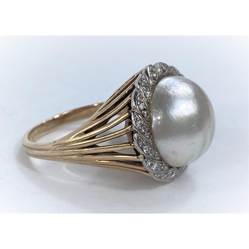 647 - A yellow metal dress ring set with a domed pearl surrounded by diamond chips in a rope twist border,... 