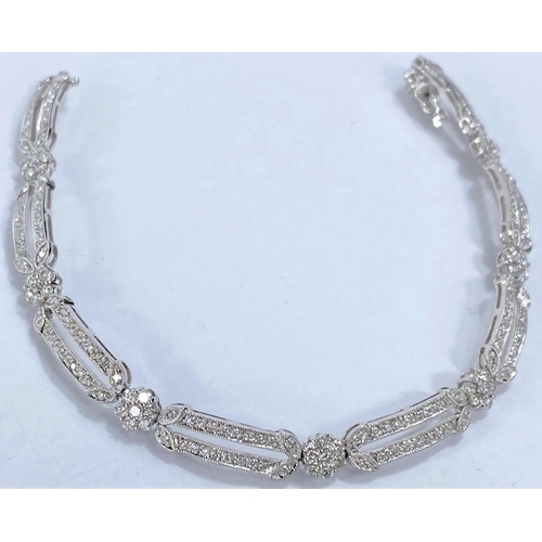 648 - A white gold Art Deco style bracelet set with alternating encrusted elongated and flower head links,... 