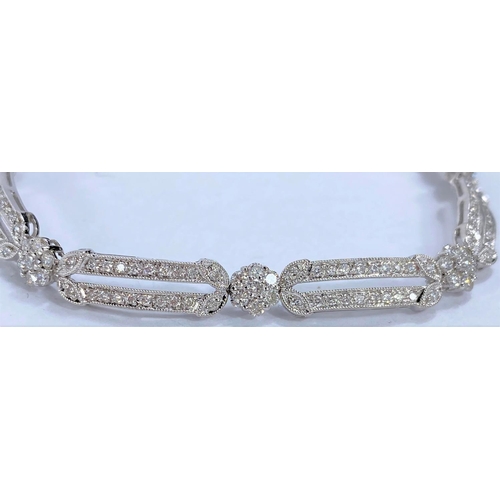 648 - A white gold Art Deco style bracelet set with alternating encrusted elongated and flower head links,... 