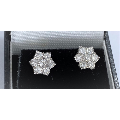 650 - A pair of white metal earrings each with 7 diamonds in flower head setting (pierced) 2.8gms