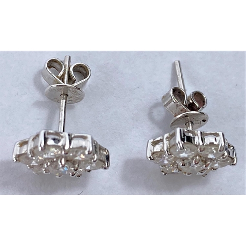 650 - A pair of white metal earrings each with 7 diamonds in flower head setting (pierced) 2.8gms