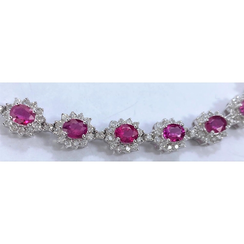 652 - A white metal bracelet with 17 flowerhead cluster links, each set with a central ruby surrounded by ... 