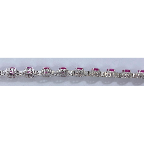 652 - A white metal bracelet with 17 flowerhead cluster links, each set with a central ruby surrounded by ... 