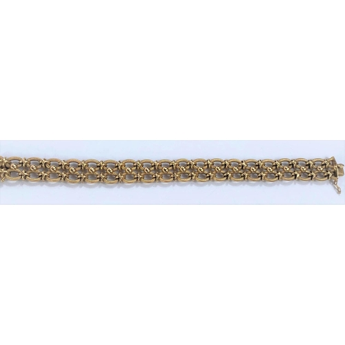 653 - A yellow metal gate bracelet formed from figure of 8 links, stamped 