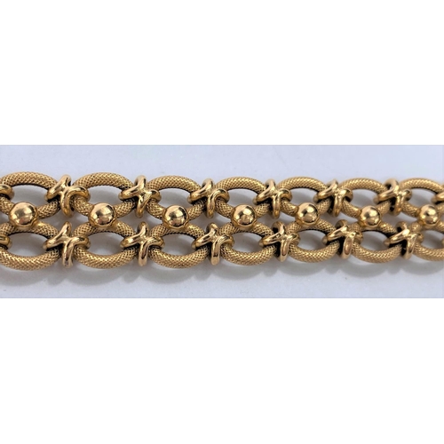 653 - A yellow metal gate bracelet formed from figure of 8 links, stamped 