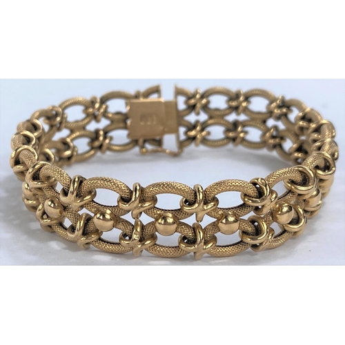 653 - A yellow metal gate bracelet formed from figure of 8 links, stamped 