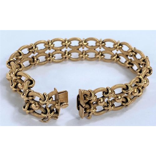 653 - A yellow metal gate bracelet formed from figure of 8 links, stamped 