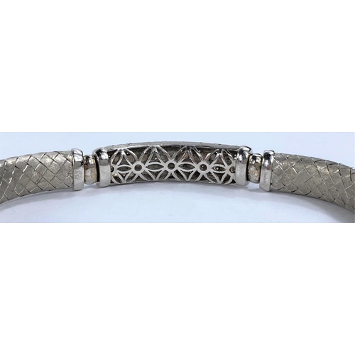 654 - A white gold  sectioned bangle with cross hatched links, the centre link pierced and diamond studded... 