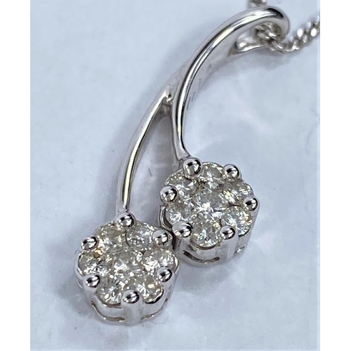 663 - An 18ct hallmarked white gold pendant set with 2 flower head diamond clusters on fine chain, 5.4gms