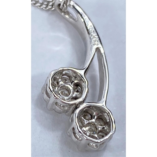 663 - An 18ct hallmarked white gold pendant set with 2 flower head diamond clusters on fine chain, 5.4gms