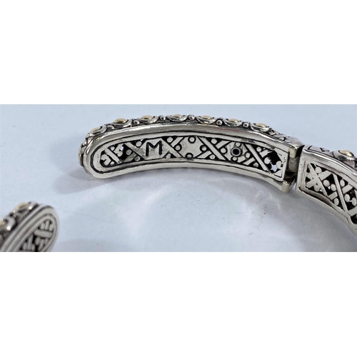 671 - John Hardy, an intricate pierced silver bangle with central circular blue topaz flanked by 2 rectang... 