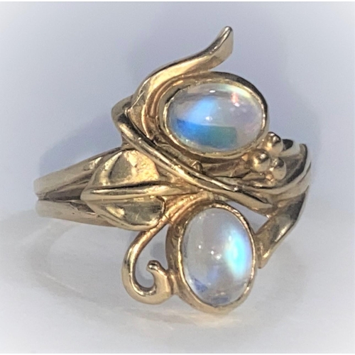 705 - A 9 carat hallmarked gold Art Nouveau style ring with 2 oval moonstones in entwined leaf and tendril... 