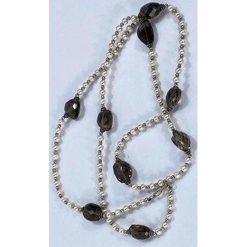 716 - A long necklace formed from cultured pearls and gold coloured beads interspersed with faceted smoky ... 