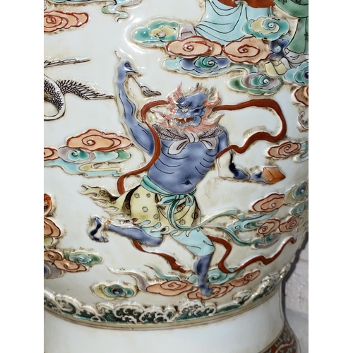 452 - A large Chinese vase decorated with deities and cranes in relief, with dragon decoration to the neck... 