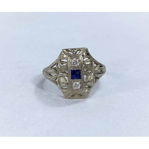 608 - An Art Deco lady's dress ring set with square cut central sapphire and 2 diamonds in raised pierced ... 