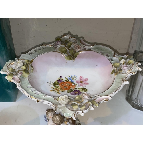 489 - A 19th century Meissen style encrusted comport with 2 cherubs to the column and all over floral deco... 