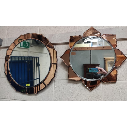 866 - A shaped circular mirror in the Art Deco style with peach border; another similar smaller mirror