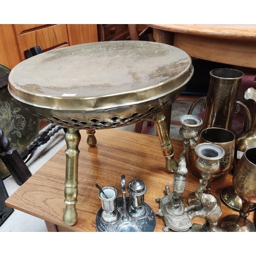 867 - An oriental brass top occasional table on folding base; a brown occasional table/foot warmer and bra... 