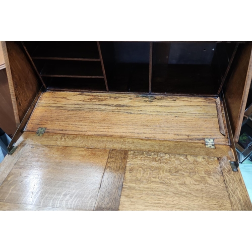 869A - A 1930's golden oak bureau with crop front and 3 drawers on bulbous legs