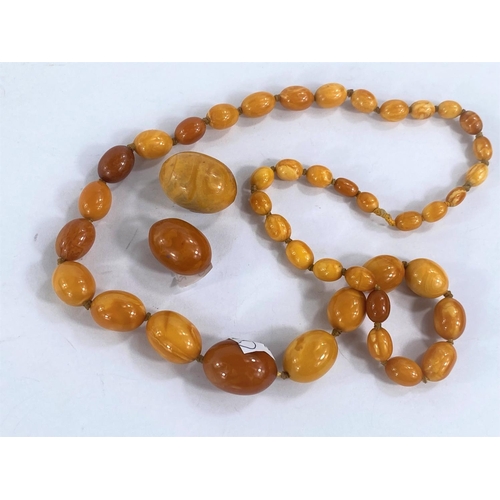 756D - A butterscotch amber coloured necklace of graduating beads and two larger loose beads,weight of  nec... 