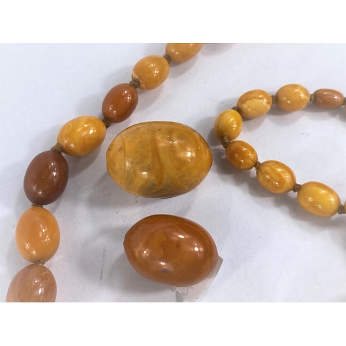 756D - A butterscotch amber coloured necklace of graduating beads and two larger loose beads,weight of  nec... 