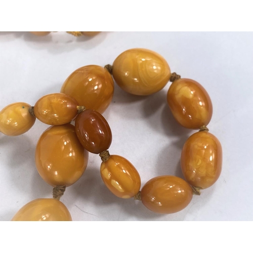 756D - A butterscotch amber coloured necklace of graduating beads and two larger loose beads,weight of  nec... 