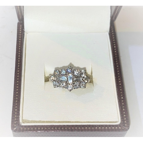 646 - An 18ct hallmarked white gold diamond cluster dress ring set with 3 baguette cut diamonds surrounded... 